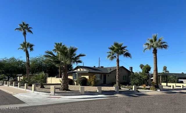 a view of a street with a building and palm trees