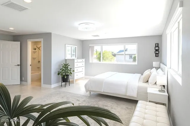 a bedroom with a bed furniture and a potted plant