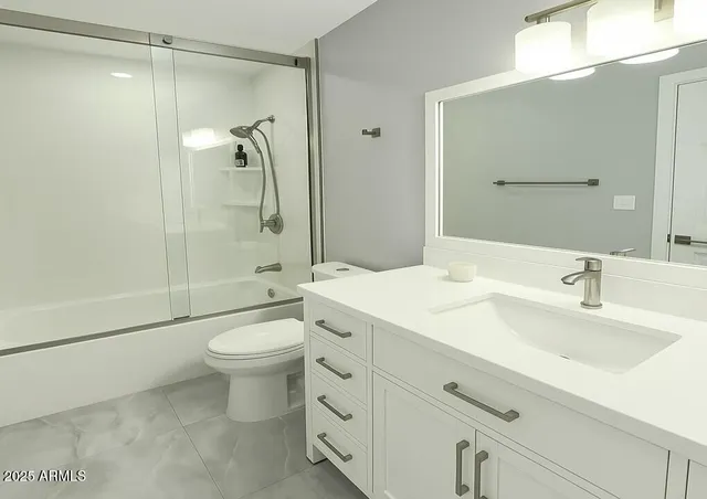 a bathroom with a double vanity sink toilet mirror and shower