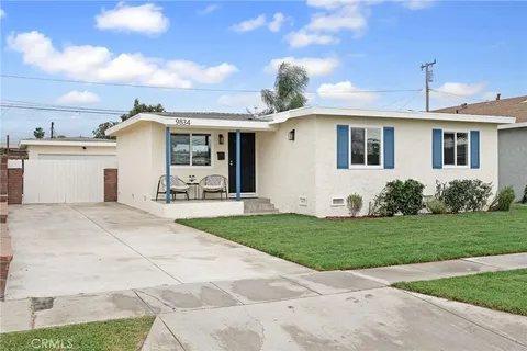 a front view of a house with a garden and yard