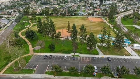 an aerial view of residential houses with outdoor space and trees