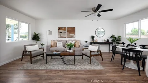 a living room with furniture a clock on wall and a window