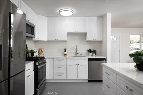 a kitchen with stainless steel appliances granite countertop white cabinets sink and dishwasher
