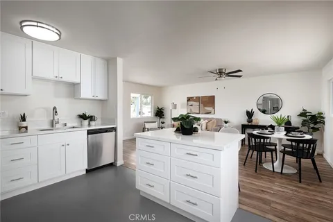 a kitchen with white cabinets and chairs