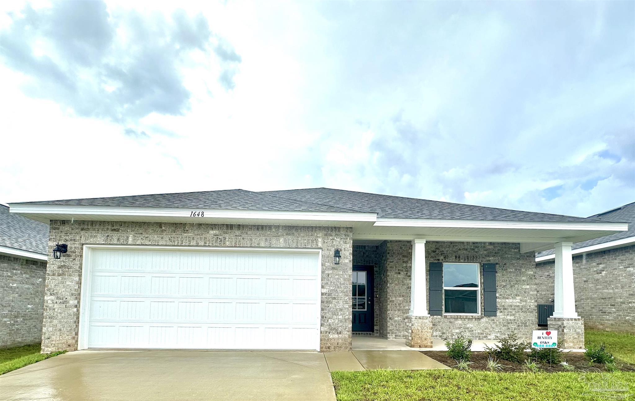 1648 Slate Drive Cantonment, FL 32533 - Photo 1 of 31 a front view of a house with garden