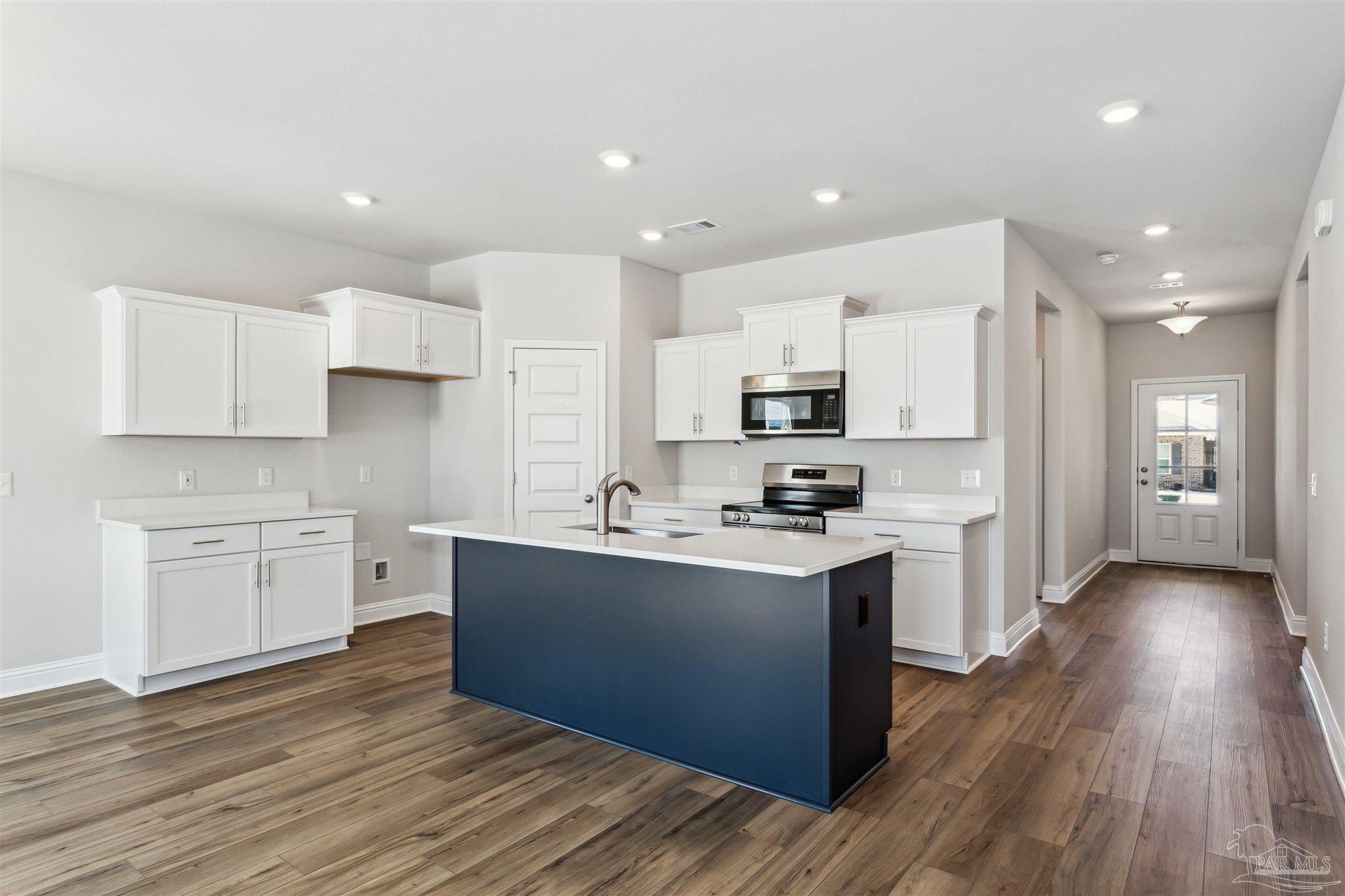 1648 Slate Drive Cantonment, FL 32533 - Photo 5 of 31 a kitchen with stainless steel appliances a sink stove and wooden floor