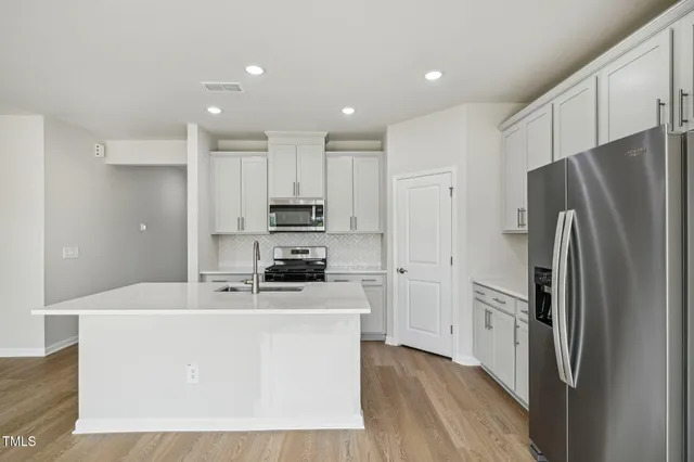 a kitchen with stainless steel appliances a refrigerator sink and stove