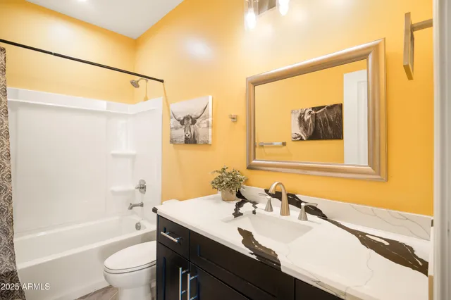 a bathroom with a granite countertop sink mirror toilet and bathtub
