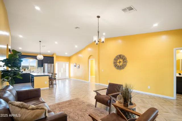 a view of a living room and a kitchen with a chandelier