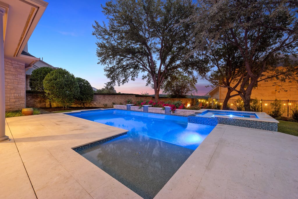5200 Rico Cove Austin, TX 78731 - Photo 36 of 40 An inviting backyard pool and spa are bordered by a smooth stone patio and mature trees.