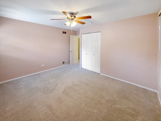 a view of an empty room with a ceiling fan