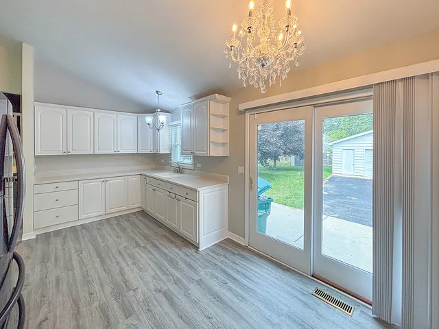a kitchen with a wooden floor window and white cabinets