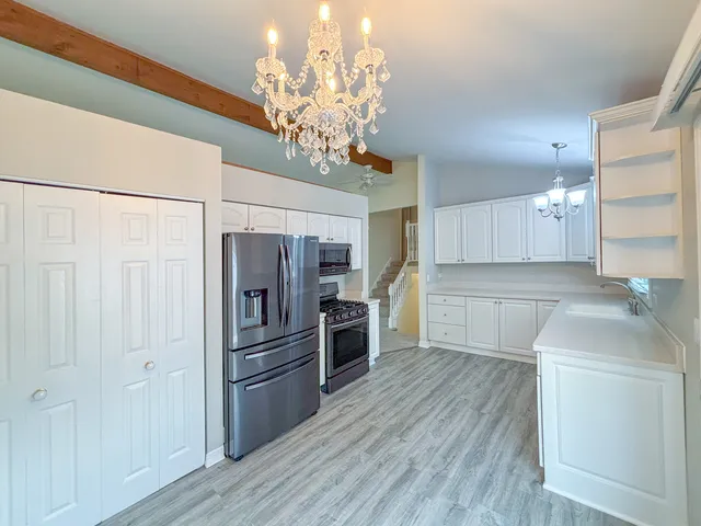 a kitchen with stainless steel appliances granite countertop a refrigerator and a sink