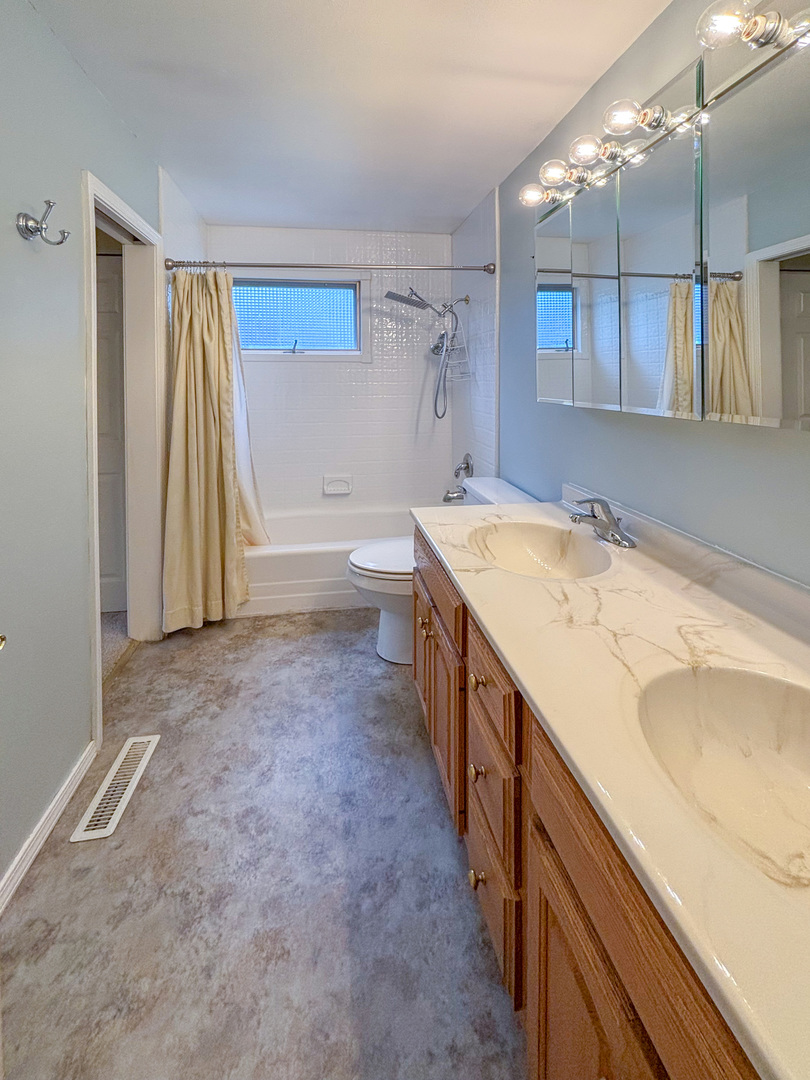 1008 18th Street Zion, IL 60099 - Photo 9 of 19 a bathroom with a granite countertop sink and a bathtub