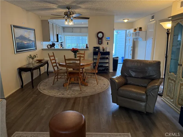 a living room with furniture a dining table and a chandelier
