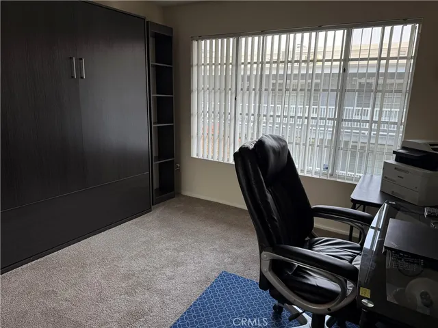 a view of a workspace with furniture and a window