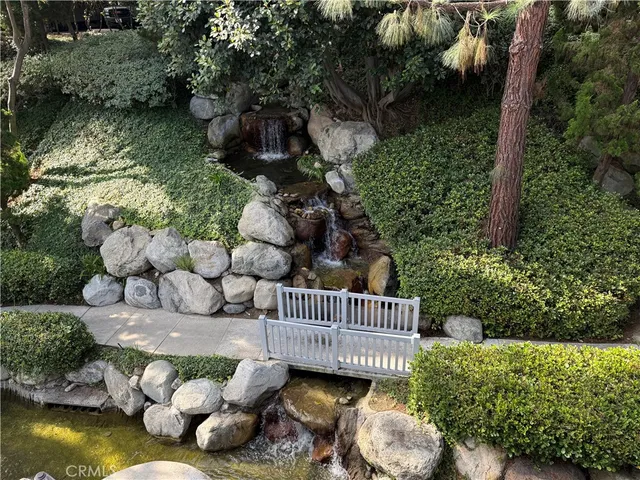 a view of a wooden house with a yard and a garden