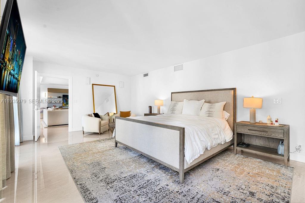 10155 Collins Avenue, Unit 1106 Bal Harbour, FL 33154 - Photo 23 of 29 a view of a bedroom with a bed and wooden floor