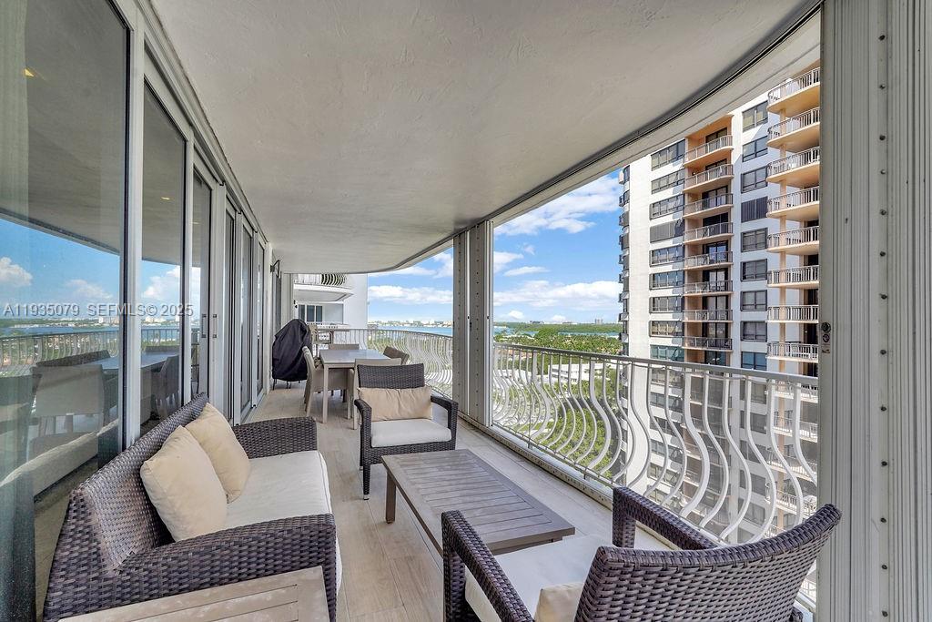 10155 Collins Avenue, Unit 1106 Bal Harbour, FL 33154 - Photo 7 of 29 a balcony view with a couch and wooden floor