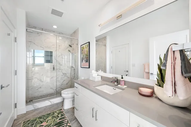 a bathroom with a double vanity sink toilet and shower