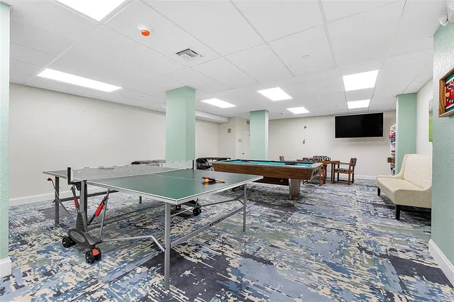 a living room with furniture pool table and a flat screen tv