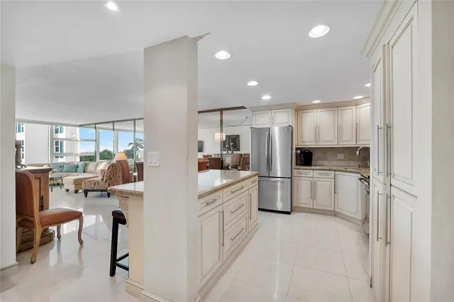 a kitchen with refrigerator and chairs