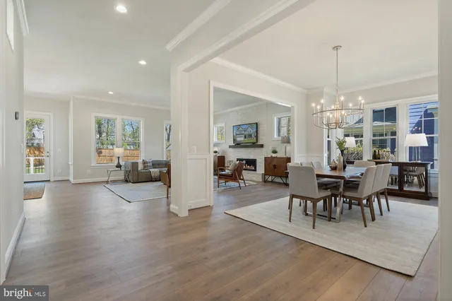 a kitchen with stainless steel appliances kitchen island granite countertop a stove a sink a refrigerator and white cabinets with wooden floor