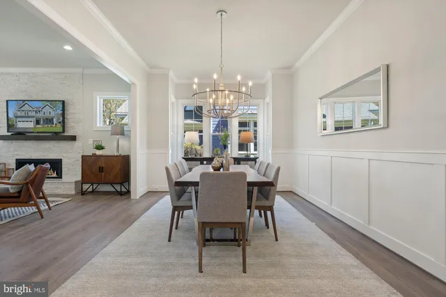 a kitchen with a stove a refrigerator and a dining table with wooden floor