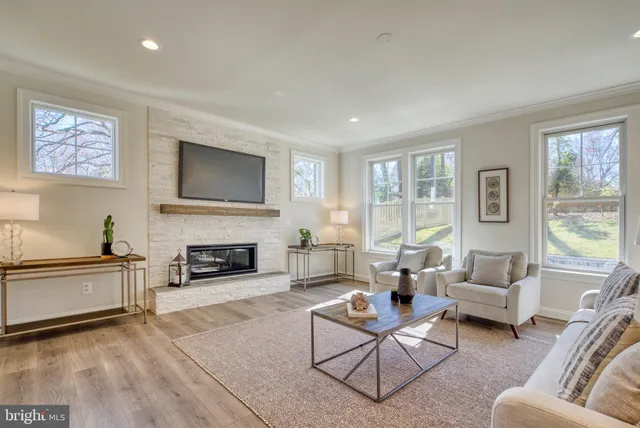 a kitchen with stainless steel appliances granite countertop a stove top oven a sink dishwasher and white cabinets with wooden floor