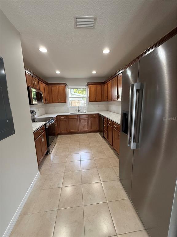 237 Northeast Gum Swamp Road Lake City, FL 32055 - Photo 12 of 34 a large kitchen with kitchen island granite countertop a refrigerator a sink and dishwasher