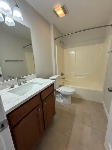a bathroom with a granite countertop sink a toilet a mirror and shower