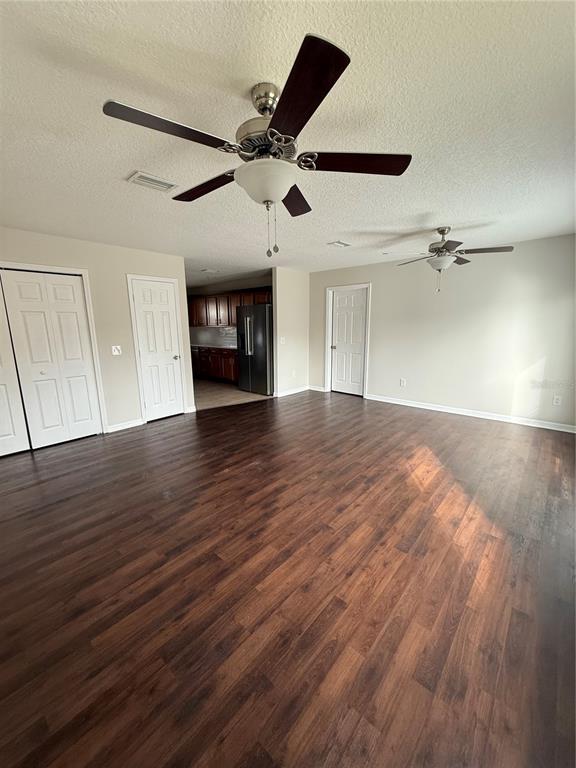 237 Northeast Gum Swamp Road Lake City, FL 32055 - Photo 10 of 34 an empty room with wooden floor ceiling fan and windows