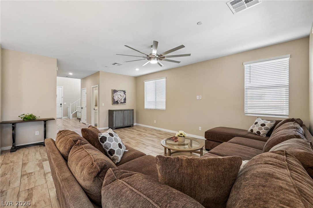 194 Viento Ridge Street Henderson, NV 89012 - Photo 7 of 72 An open-concept living area features durable tile flooring and abundant natural light from large windows.