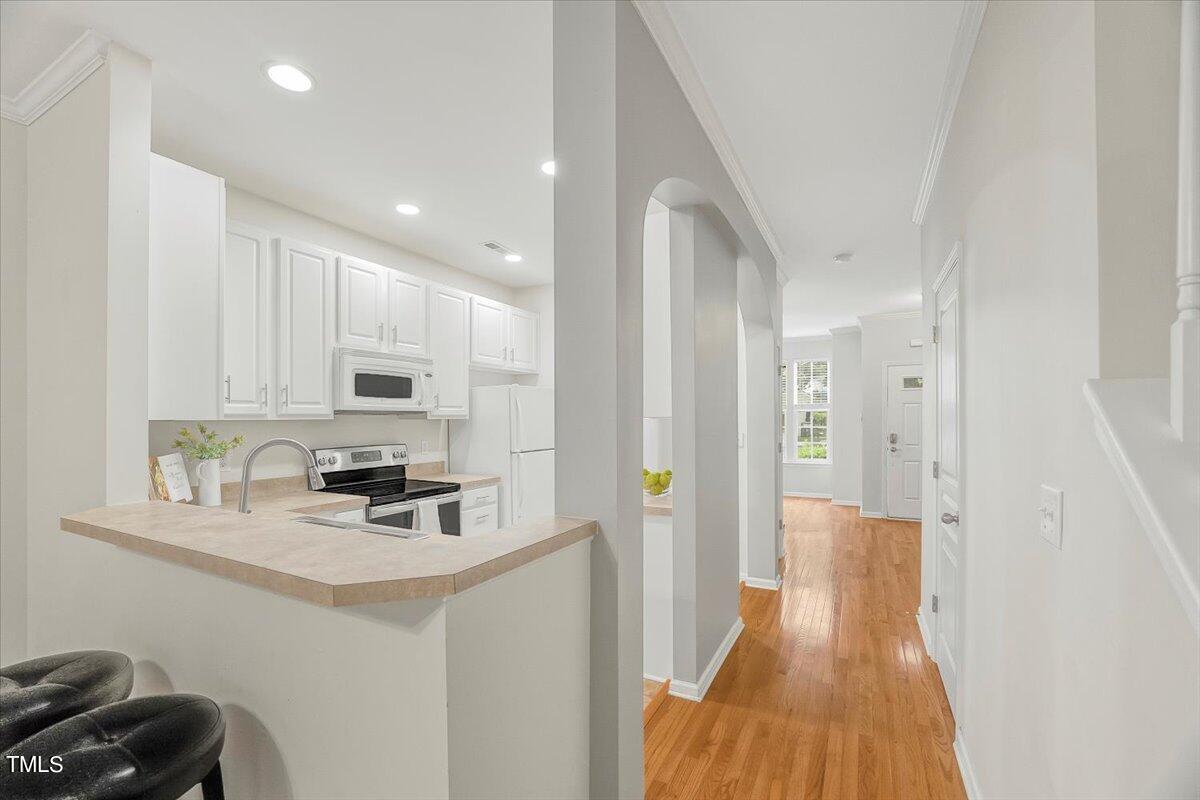 4508 Sugarbend Way Raleigh, NC 27606 - Photo 13 of 39 a kitchen with stainless steel appliances a refrigerator a sink a stove and white cabinets
