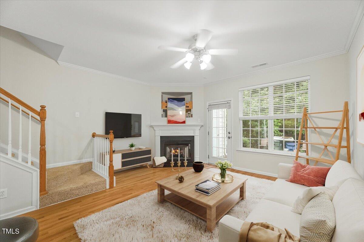 4508 Sugarbend Way Raleigh, NC 27606 - Photo 14 of 39 a living room with furniture a fireplace a flat screen tv and a large window