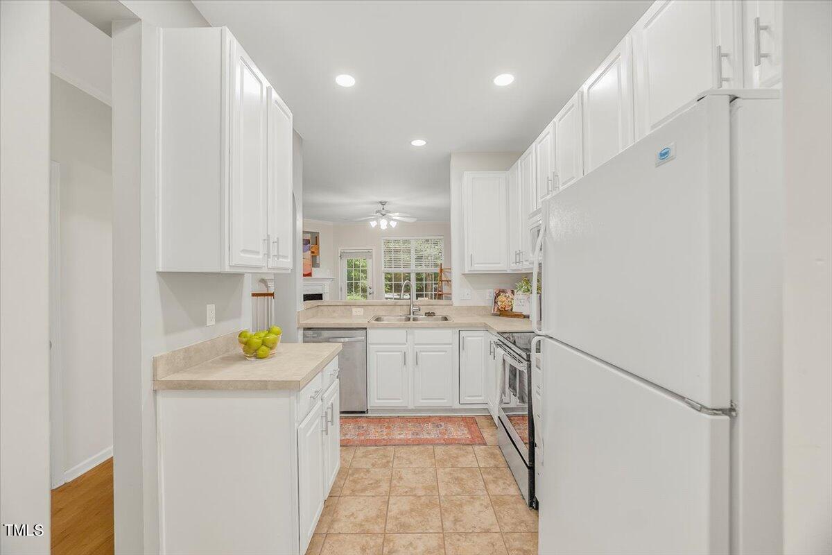 4508 Sugarbend Way Raleigh, NC 27606 - Photo 9 of 39 a kitchen with white cabinets and appliances