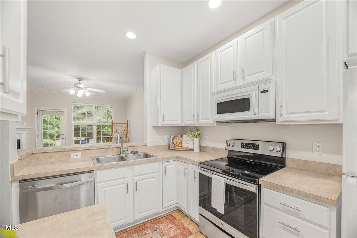4508 Sugarbend Way Raleigh, NC 27606 - Photo 10 of 39 a kitchen with granite countertop white cabinets white stainless steel appliances a sink and a window