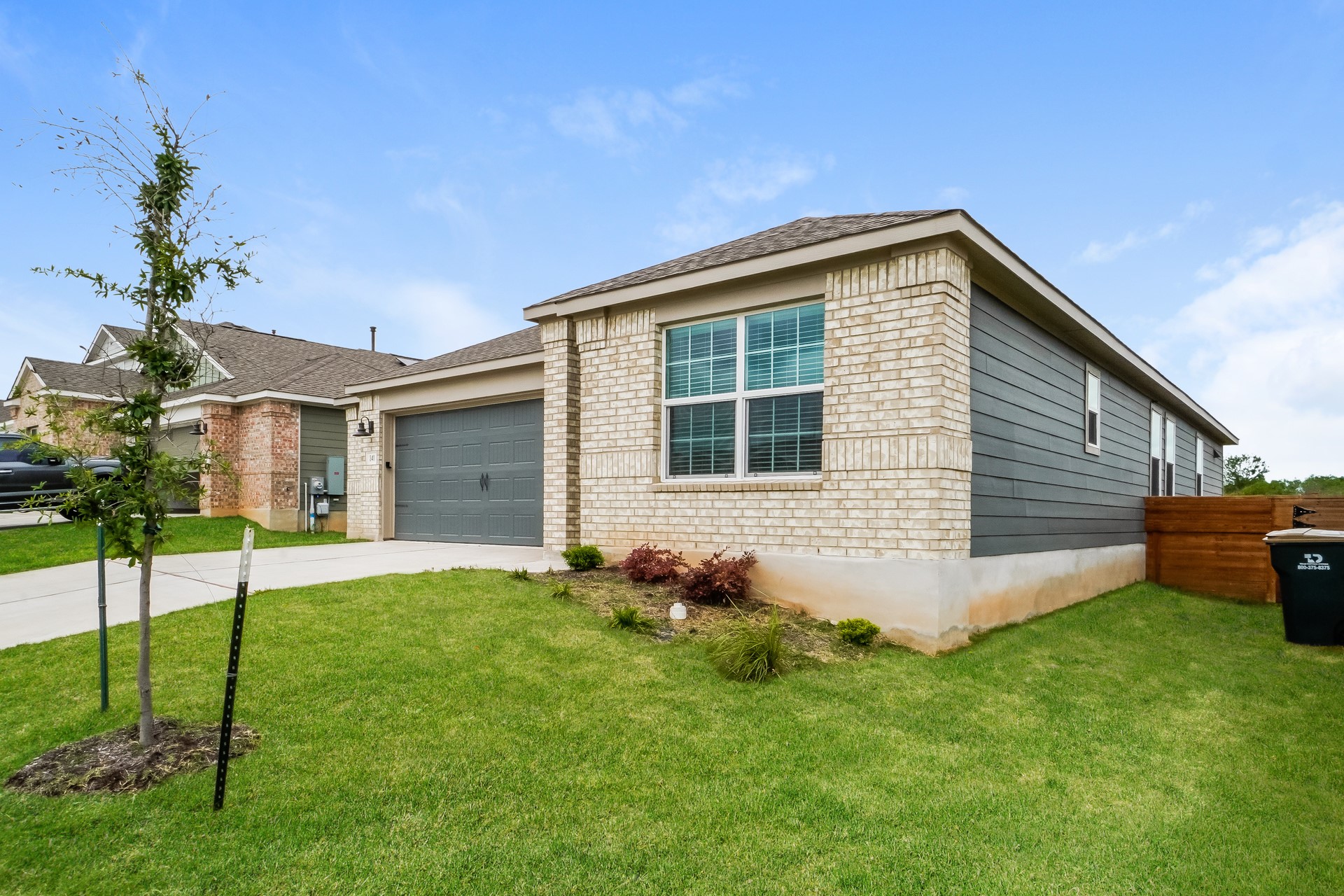 341 Madrid Kyle, TX 78640 - Photo 3 of 27 A well-maintained lawn and sturdy brick exterior create inviting curb appeal.