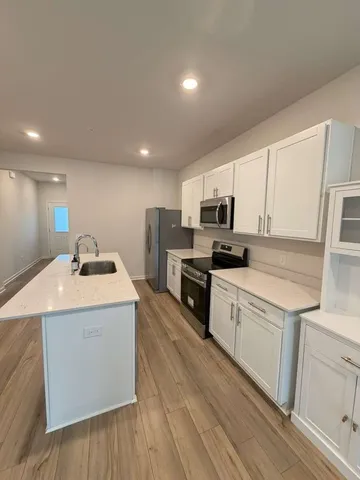 a kitchen with granite countertop a sink and a stove top oven