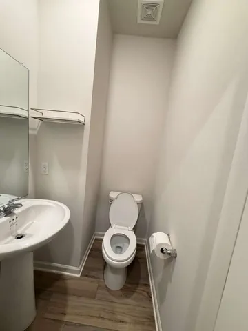 a bathroom with a toilet a sink and mirror