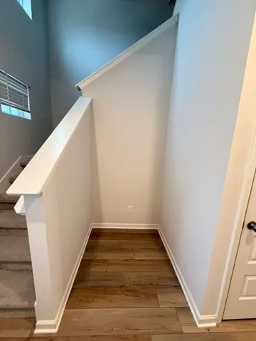 a view of a hallway with wooden floor and staircase
