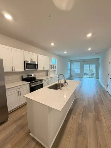 a open kitchen with kitchen island a sink and white appliances