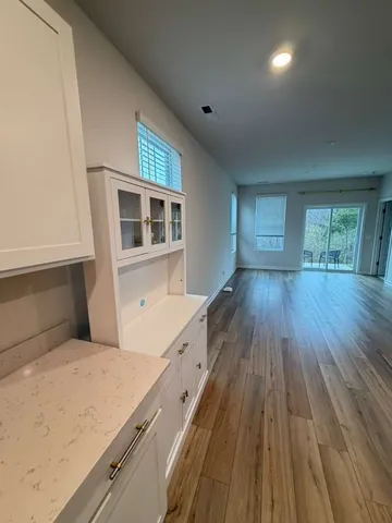 a hallway with wooden floor and cabinet