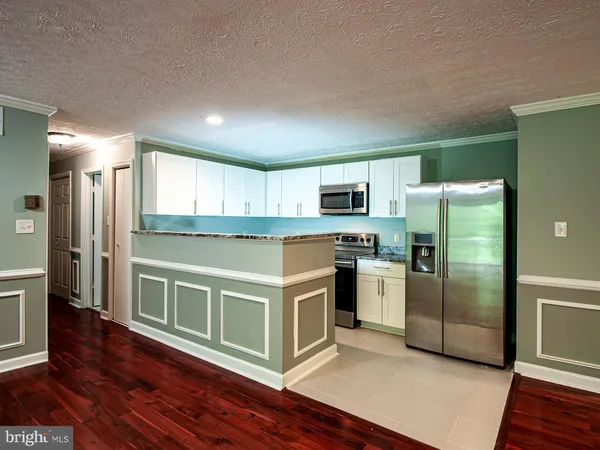 a kitchen with stainless steel appliances granite countertop a refrigerator a stove and a sink