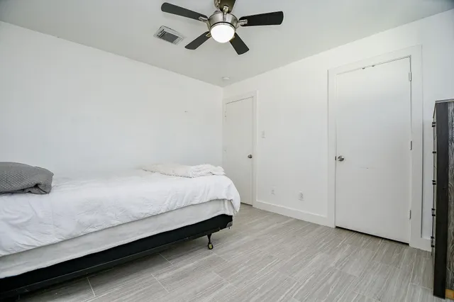 a bedroom with a bed and a ceiling fan