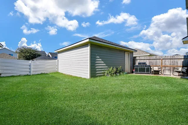 a backyard of a house with table and sofas