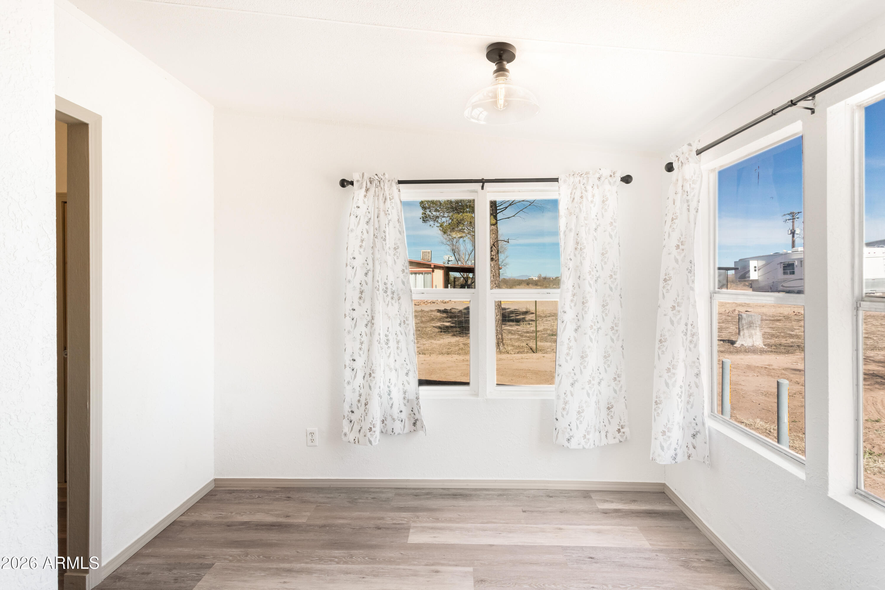 10405 North Mormon Road Elfrida, AZ 85610 - Photo 15 of 43 a view of an empty room with wooden floor and a window