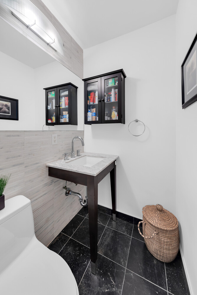 1438 3rd Avenue, Unit 7A Manhattan, NY 10028 - Photo 3 of 12 a bathroom with a sink a mirror and a toilet