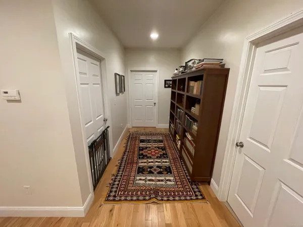 a view of a hallway with wooden floor and staircase