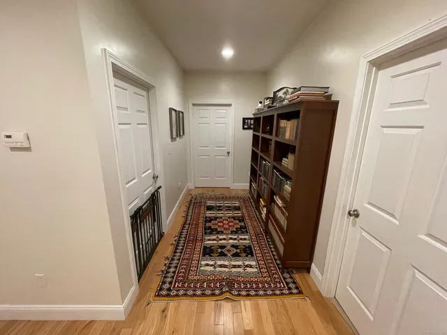 a view of a hallway with wooden floor and staircase